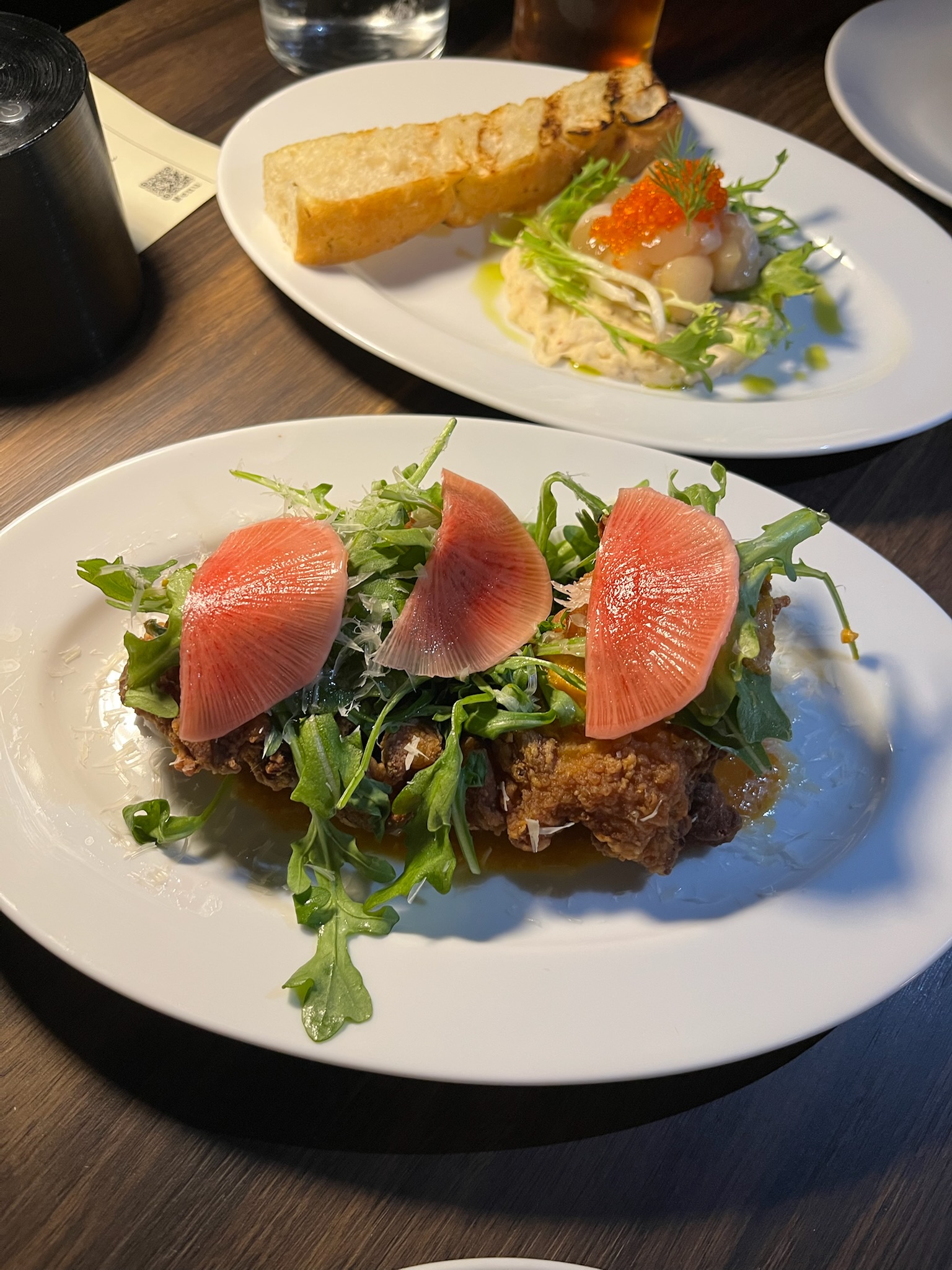 Fried chicken close-up with fanned watermelon radish, arugula, and grana padano