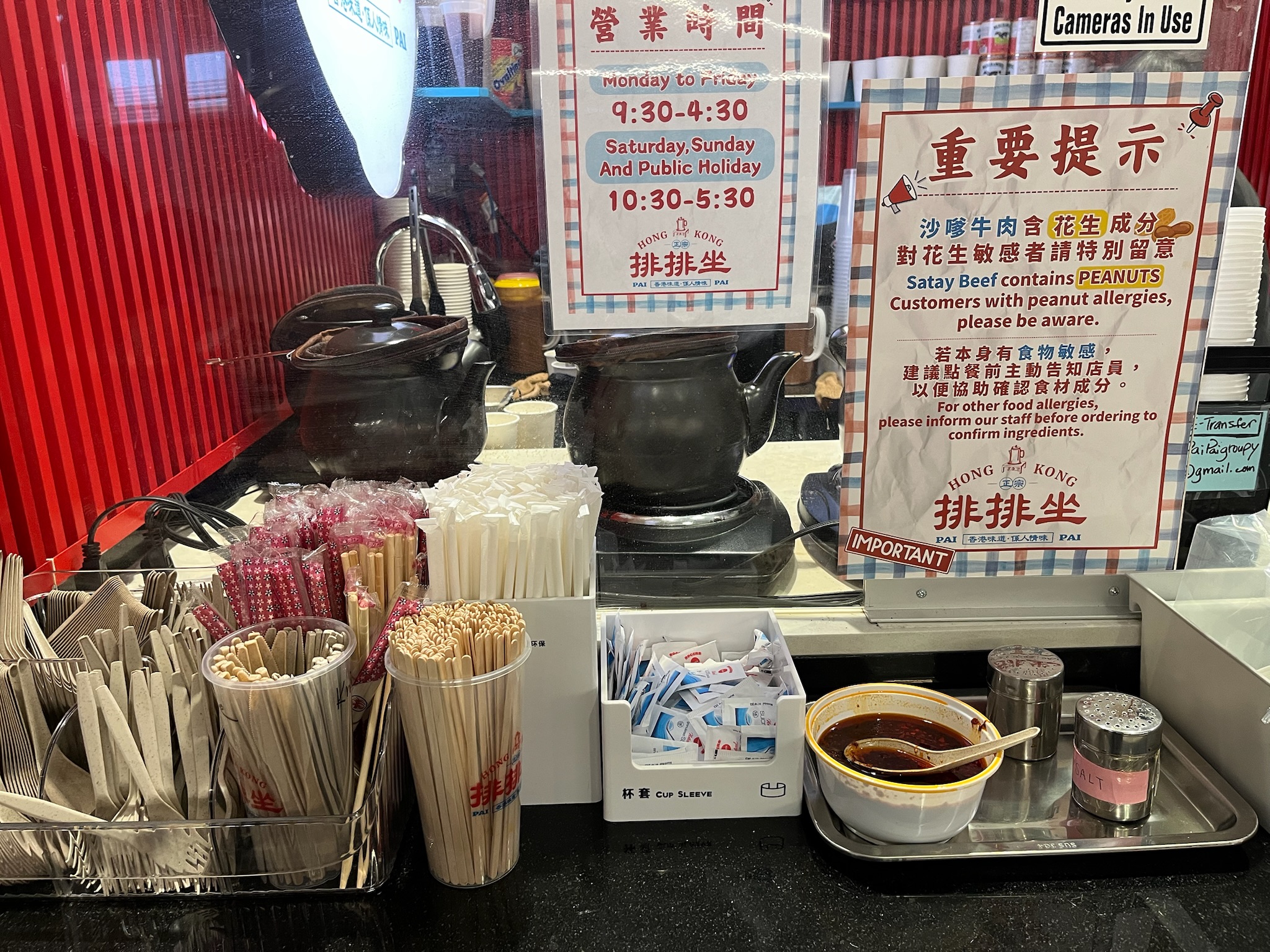 The Hong Kong Pai Pai counter with clay pots, chopsticks, condiments, and posted hours
