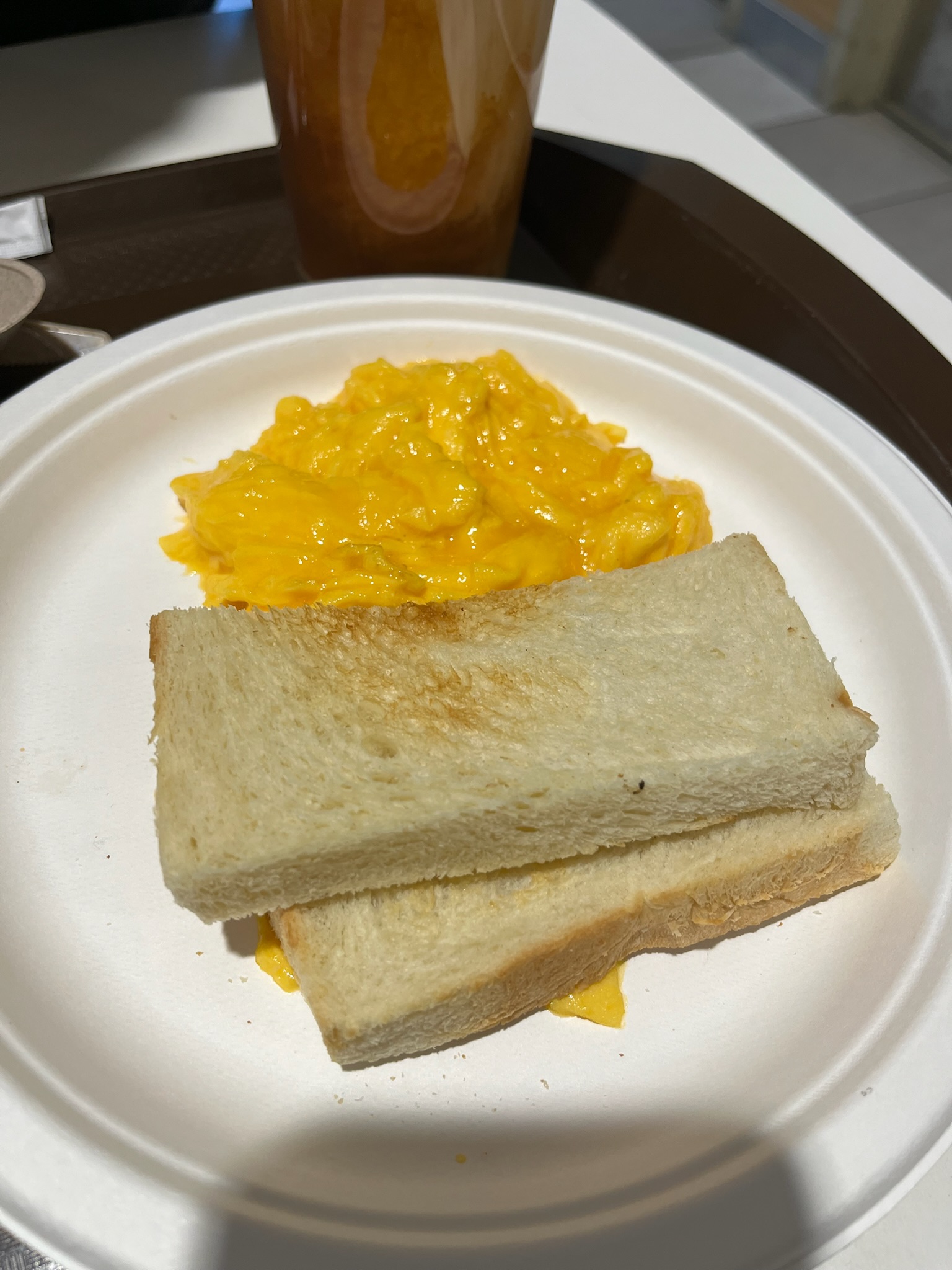 Silky scrambled eggs and butter toast served alongside the iced milk tea