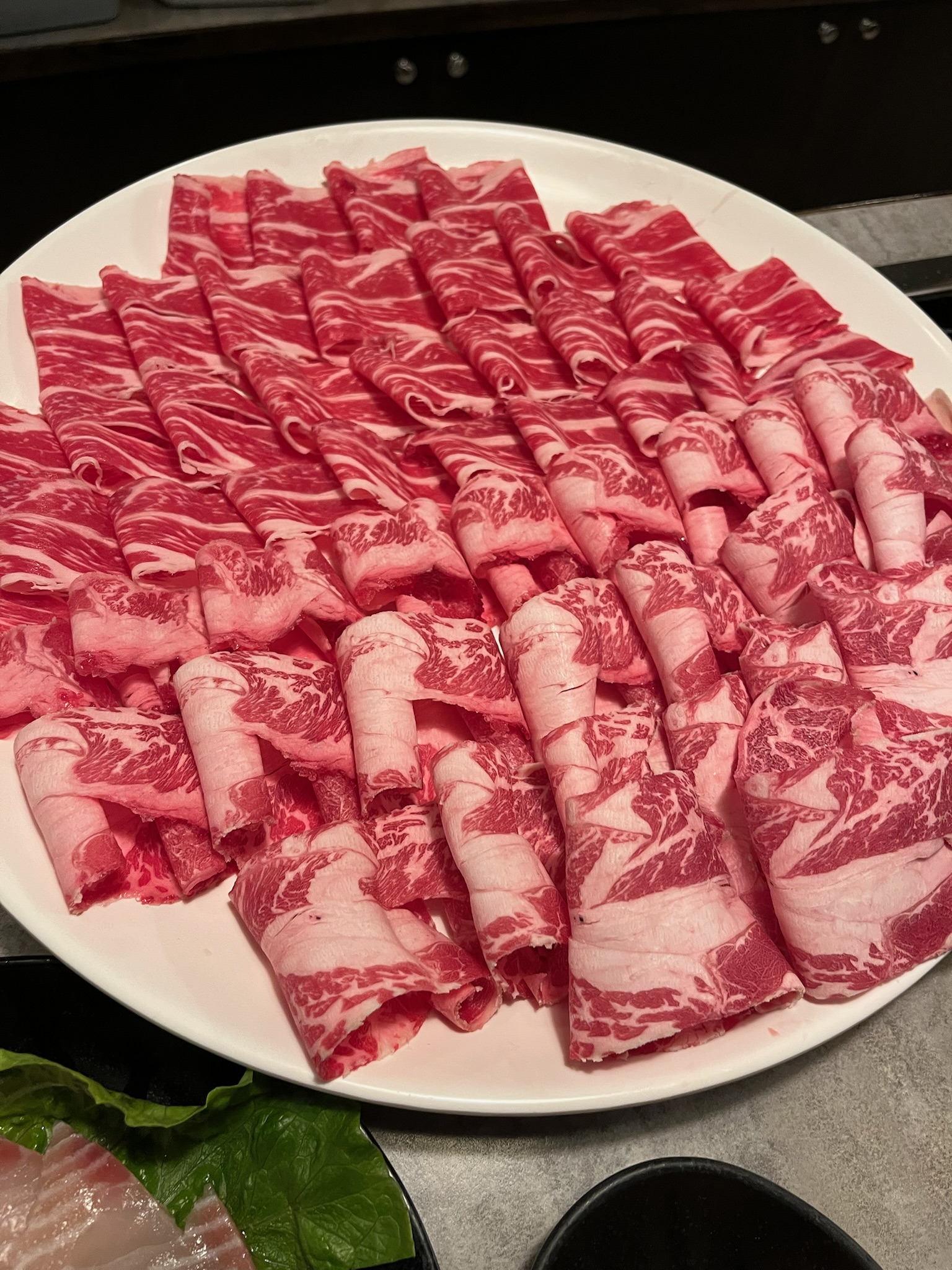 Thinly sliced short rib with generous marbling, rolled and plated