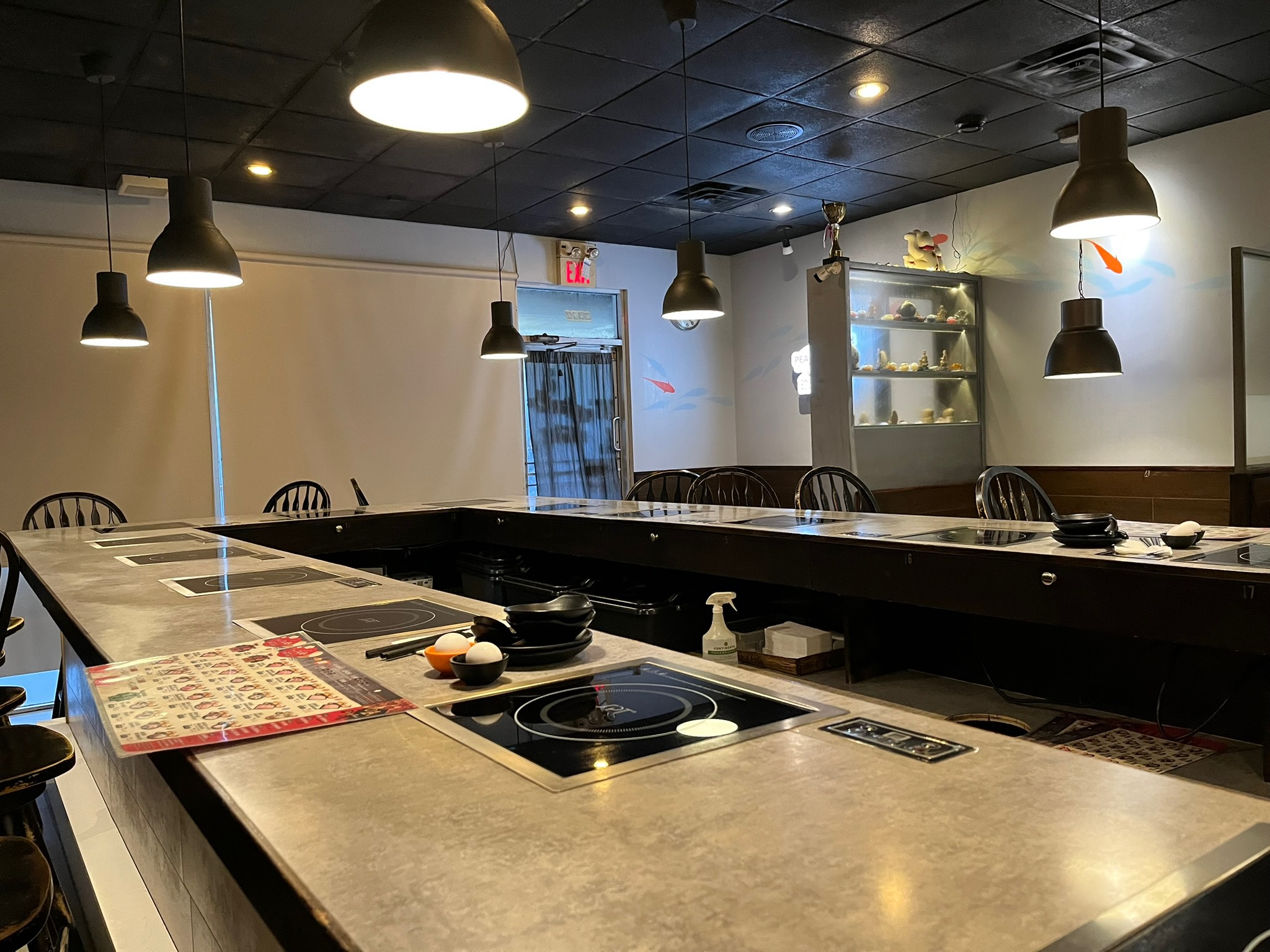 Bar-style dining room with high counter seating and individual induction cooktops